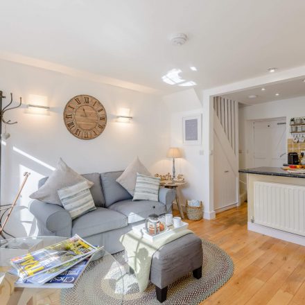 Living room in Tegfan cottage, Aberdyfi with sofa, table, TV and open plan Kitchen